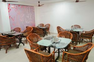 a dining room with tables and chairs at Hotel RD in Perundurai