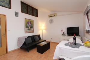 un soggiorno con un divano e una TV di Apartments Villa Nikola a Rovigno (Rovinj) Altre 30 foto