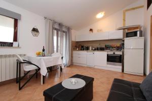 un soggiorno con un tavolo e una cucina di Apartments Villa Nikola a Rovigno (Rovinj)