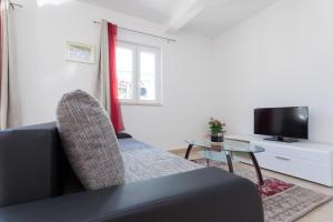 - un salon avec un canapé, une table et une télévision dans l'établissement Apartment Rubidus A50, à Dubrovnik