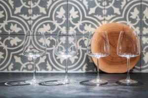 four wine glasses sitting on a table next to a bowl at 貸別荘 山くじら in Kanoya
