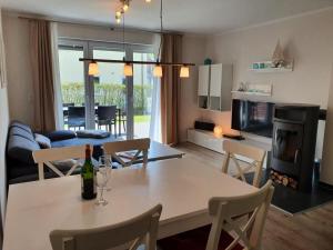 Una cocina y una sala de estar con mesa y sillas. en 42 Ferienwohnung im Birkenweg 1c EG, en Burg auf Fehmarn