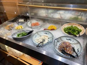 a buffet with plates of food on a counter at Travelodge Kyoto Shijo Kawaramachi in Kyoto