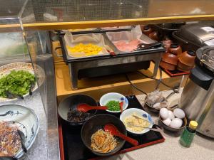 a kitchen with many dishes of food on a counter at Travelodge Kyoto Shijo Kawaramachi in Kyoto