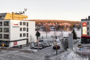 a parking lot with cars parked in front of a building at Santa's Luxury City Apartment 3 in Rovaniemi