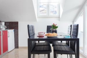 a black dining room table with chairs and a plate of food on it at Apartment Igneus A51 in Dubrovnik