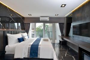 曼谷Victora Hostel的一间带大床和电视的卧室