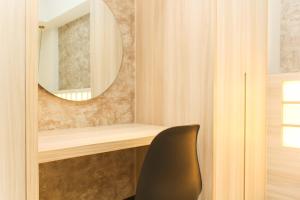 a mirror and a chair in a room at Modern and Spacious Studio Apartment at Mustika Golf Residence By Travelio in Cikarang +10 photos