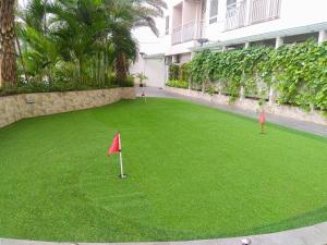a golf course with red flags on the grass at Modern and Spacious Studio Apartment at Mustika Golf Residence By Travelio in Cikarang