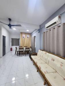 un salon avec des canapés et une salle à manger dans l'établissement Sandakan Corner Terrace House, à Sandakan