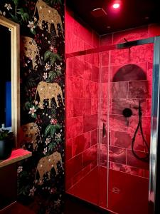 eine rote Dusche im Bad mit einer roten Wand in der Unterkunft Escale Singulière - Luxe & balnéo à Sète in Sète + 15 Fotos