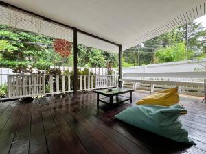 a porch with a couch and a table on a wooden floor at Charming Getaway in Koh Chang in Ko Chang