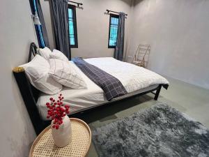 a bedroom with a bed and a table with a vase of flowers at Charming Getaway in Koh Chang in Ko Chang