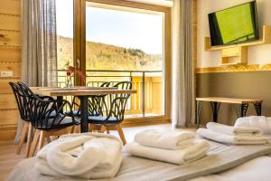 a room with a table and chairs and a balcony at Bella Monte in Szczyrk