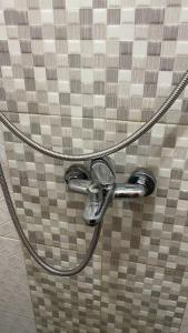 a shower faucet in a bathroom with a tile wall at DYAZA LV Grogol Guest House in Jakarta +38 photos
