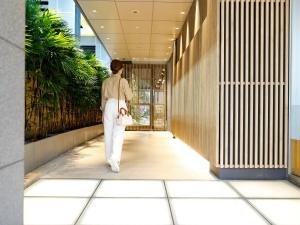 a woman walking down a hallway in a building at Travelodge Kyoto Shijo Kawaramachi in Kyoto