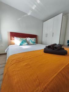 a bedroom with a large bed with an orange blanket at Sea Breeze 201 in Skála Neón Epivatón +14 photos