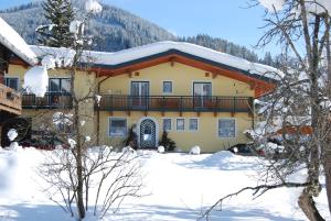 ein großes Haus mit Schnee auf dem Dach in der Unterkunft Ferienhaus Emberger in Wagrain