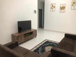 a living room with two couches and a flat screen tv at SK Villa's Homestay Kota Warisan, Dengkil, KLIA in Sepang