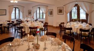 a room full of tables and chairs with white tablecloths at Schloss zu Hopferau in Hopferau