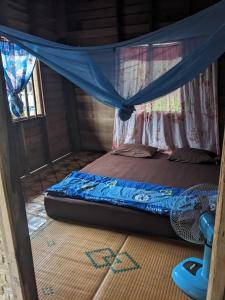 a bed in a room with a mosquito net at Mama Pap - Tad Lo in Ban Donkhagnoung +8 photos