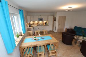 een keuken en woonkamer met een tafel en stoelen bij Ferienhaus Meerjungfrau in Altefähr