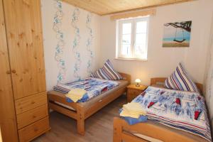 een slaapkamer met twee bedden en een raam bij Ferienhaus Meerjungfrau in Altefähr