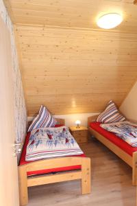 een slaapkamer met 2 bedden in een houten kamer bij Ferienhaus Meerjungfrau in Altefähr +9 foto's