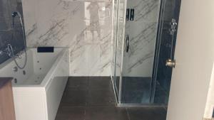 a bathroom with a shower with a tub and a shower stall at Olivia Resort and Spa a unit of Falgu Resorts Pvt Ltd in Kolār +23 photos