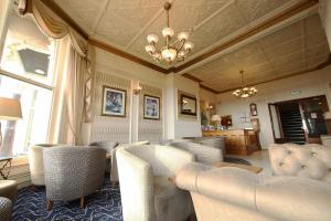 a living room with chairs and a chandelier at The Hydro Hotel in Douglas