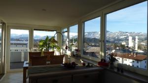 a room with large windows with a view of mountains at PenthouseApartment 250° in Sonthofen