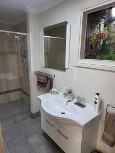a white bathroom with a sink and a shower at Apartment on Mica in Broken Hill +15 photos
