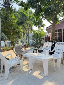 a group of white chairs and tables on a patio at Rang Noknoy Resort at Kohlarn in Ko Larn