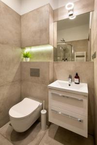 Un baño con inodoro, lavabo y espejo. en Discover Krakow Apartments - Lubicz St - Loft - Next to Main Station, AC, en Cracovia