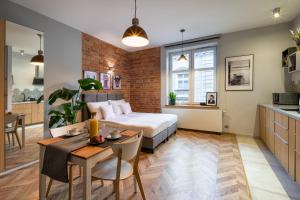 Un dormitorio con una cama y una mesa y una cocina. en Discover Krakow Apartments - Lubicz St - Loft - Next to Main Station, AC, en Cracovia