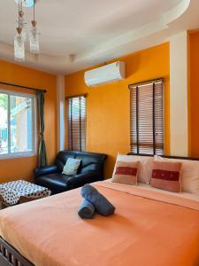 a bedroom with a large bed and a chair at Rang Noknoy Resort at Kohlarn in Ko Larn