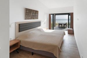 ein Schlafzimmer mit Bett und Blick auf das Meer in der Unterkunft Luxury Beach Villa 6p - 10m van het Grevelingenmeer - Villa 17 in Ouddorp