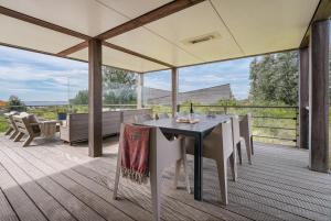 a patio with a table and chairs on a deck at Exclusive Duin Villa - 6p - Direct bij Natuur & Strand - Villa 70 in Ouddorp