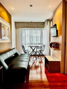 un salon avec un canapé et une table avec des chaises dans l'établissement DREAMS APARTMENTS by ART PATONG RESIDENCE, à Patong Beach