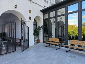 a patio with two benches and a gate at Hotel Apollonia in Braşov