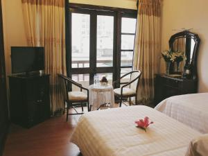 a hotel room with two beds and a television at Jasmine Hotel in Hue