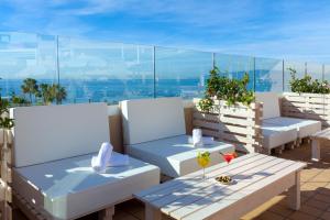 a balcony with white chairs and tables with a view at Aparthotel Los Dragos del Sur in Puerto de Santiago