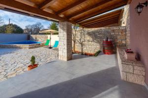 a patio with a stone wall and a swimming pool at House Edo in Svetvinčenat