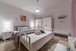 a bedroom with a white bed and a white cabinet at House Ingrid in Rijeka