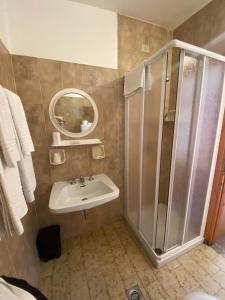 łazienka z prysznicem i umywalką w obiekcie Hotel Eira w mieście Bormio +37 zdjęć