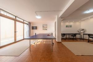 a ping pong table in the middle of a room at MEDANO4YOU Casa Violeta in El Médano