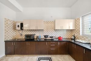 a kitchen with wooden cabinets and a counter top at Susan Grand penthouse in Bangalore