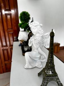 a white angel statue next to a eiffel tower at The Dream Stay Villa in Puducherry