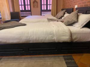two beds with white blankets and pillows in a room at Bhaktapur Boutique Hotel and Restaurant in Bhaktapur