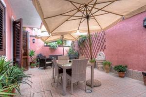 a patio with a table and an umbrella at B&B Epos Acitrezza in Acitrezza